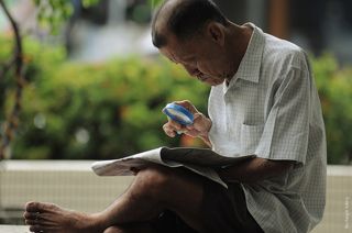 Житель Джордж тауна, читает утреннию газету.