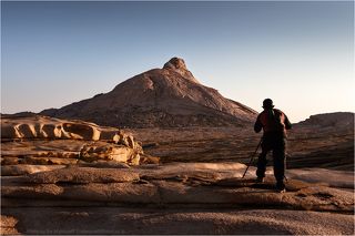13 сентября 2011 г. 7:39. Мой друг Антон и Бектау-Ата.
Стартовали мы классически - 3 машины выехали из Алматы в северном направлении ещё до 8 утра. Команда подобралась супер: 9 фотофанатов плюс два туриста. Промежуточную ночёвку мы сделали в нашем любимом лагере в районе Бектау-Ата. Облаков не было, воды в водоёмах – тоже, на закате и на восходе фотографировали голые камни.


Справка. Горный массив Бектауата - оазис Северного Прибалхашья, находится в 70-ти километрах на север от города Балхаш. На высоту более восьмиста  метров от уровня степи взметнулся розовый пик Бектау-Ата. Высота на вершине около 1200 над уровнем моря.  В ясную погоду его можно видеть за сотню километров, поэтому его не зря называют маяком Прибалхашья. 
В урочище Бектау-Ата произрастают сотни видов растений, из которых 45 являются редкими, а 8 занесены в Красную Книгу.
Горный массив Бектау-Ата невелик по площади (4000 га), но он вместил в себя необыкновенное многообразие причудливых скал, тернистых ущелий. Со спутника Бектау-Ата напоминает приплюснутую полусферу. По оценкам некоторых геологов этот горный массив – продукт некогда так и не проснувшегося вулкана. Бектау-Ата трудно перевести дословно. С названием горы связана легенда о Святом Атабеке: этот праведник жил в столетие, когда казахи воевали с джунгарами. Однажды он, спасаясь от погони, укрылся в самой большой пещере горы, а Аллах создал святому старцу в глубине ее источник пресной воды. Враги не могли найти эту пещеру, потому что она расположена не у подножия, а на высоте, в отвесной скале.