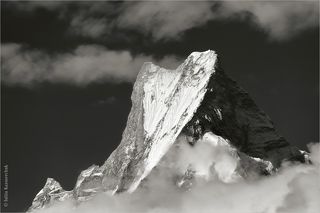 Своим названием гора обязана форме двух её вершин, которые, при взгляде с запада, образуют фигуру, напоминающую хвост гигантской рыбы. Взгляд из Чомронга.