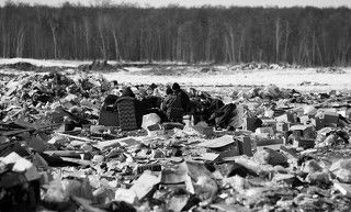 Когда Пашка с матерью оказался на свалке, ему было 14 лет. Их дом – аварийная развалюха – сгорел дотла, их поселили в «маневренном фонде». Еще большей развалюхе. Судьба зло пошутила: сгорел и маневренный барак. Пашка с мамой выскочили в чем спали – рубахе и нижнем белье. Ни документов, ни денег, ни одежды.   Было это в 2004 году.   Первое лето на свалке семья провела в палатке из тепличной пленки. Вставали рано и шли на полигон собирать все, что может пригодиться: цветмет, одежду, утварь, доски, куски фанеры.   Днем собирали и сдавали металл, по ночам Пашка строил избушку — торопился до холодов. Марина Васильевна, мать Пашки, помогала по мере сил: выпрямляла старые гвозди, обустраивала быт.