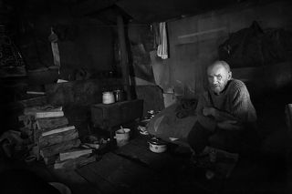 Хмурый и не разговорчивый мужик. Он прожил в землянке на свалке около 15 лет. Он мог отвесить крепкого словца, если что-то шло в разрез с его понятиями по жизни. Человек, который, сидя на куче мусора, мог дать анализ всему происходящему в мире, зачастую говоря при этом афоризмами и высказываниями великих людей. Историк по образованию и человек, который сам выбрал этот жизненный путь.