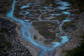 Довольно любопытное образование. Похоже на выход воды из карстовой полости внутри морены. Необычный цвет, по всей видимости, связан с высоким содержанием в ней карбонатов