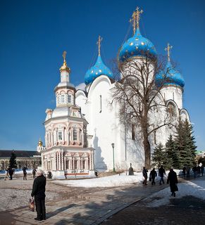 Успенский собор (1585) и Успенский кладезь с часовней (1644 г. – кон. XVII в.). Успенский собор, сооруженный по повелению царя Иоанна Грозного, строился на протяжении 1559–1585 гг. По своей архитектуре пятиглавый Успенский собор очень близок послужившему для него образцом одноименному собору Московского Кремля, превосходя его по размерам. Это самый большой храм Троицкого монастыря, но поставлен он так, что его торжественное величие не подавляет собой другие, более древние и меньшие по размерам постройки монастыря. Успенский собор ограничивает соборную площадь с востока.    Под стать величественному собору и фресковая живопись, покрывающая его стены, столпы и своды. Она была выполнена в 1684 г. артелью ярославских и троицких иконописцев, возглавляемых известным мастером Дмитрием Григорьевым. Особую торжественность внутреннему убранству собора придает огромный пятиярусный резной иконостас начала XVIII в. с иконами XVII в. и два прекрасных бронзовых паникадила работы Оружейной палаты (XVII в.).    Главными святынями собора являются покоящиеся в нем мощи святителя Иннокентия, митрополита Московского и преподобного Максима Грека, открытые для поклонения в теплое время года, когда Успенский собор становится главным храмом, в котором совершаются монастырские богослужения: всенощные бдения (начало в 17 час.) и Божественные литургии (начало в 5 час. 30 мин. и в 9 час. 30 мин.). Успенский кладезь был устроен в 1644 г. у юго-западного угла Успенского собора над открывшимся здесь источником целебной воды. Возведение часовни над ним относится к концу XVII в.     Часовня по форме подобна миниатюрному четырехъярусному храму, увенчана куполом и крестом и, как другие постройки монастыря конца XVII в., богато украшена резьбой и покрыта многоцветной росписью. Строгие белые стены величественного Успенского собора, рядом с которым расположена Надкладезная часовня, подчеркивают праздничность ее убранства.     Стенная роспись интерьера часовни и иконы относится к XIX в.    Надкладезная часовня открыта ежедневно с 9 до 21 час.