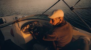Golden light embracing the helmsman, a quiet portrait of serenity at sea.