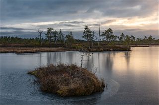 Просветы в тяжёлых облаках над замёрзшим озером