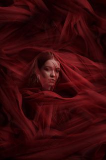 Фотография девушки в студии с красной вуалью