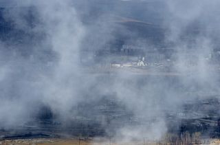 Периодически дым рассеивается и становится виден город