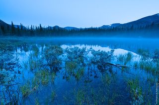 Над безымянным круглым озером поднимается туман