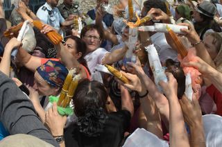 Это продолжалось около 2-3 минут, до тех пор, пока все желающие не зажгли свои охапки со свечками.