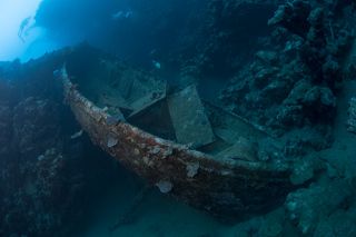 Рядом с кораблем лежит спасательная шлюпка.