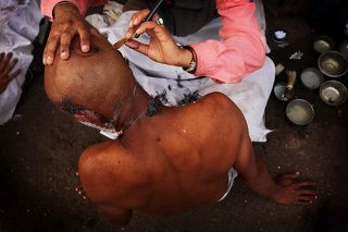 Родственники покойных бреют головы перед обрядом кремации.