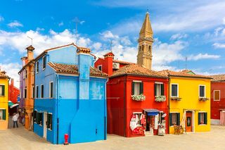Colorful houses and church on the famous island Burano, Venice, Italy