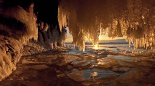 Заходящее солнце залило золотым светом обледеневший грот и сосульки засияли как драгоценные камни.