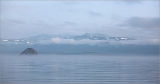 Когда-то давным-давно на Камчатке бабахнула большая гора. Сильно!  Говорят, что куски долетели до Новой Зеландии. А на месте горы осталась воронка, которая постепенно наполнилась водой. Так появилось озеро Курильское. Между прочим, второе по глубине после Байкала (глубже 300 м!). В озеро нашла дорогу нерка (лосось такой), а за неркой потянулись медведи. Ну, а за этими, понятное дело, - фотографы-натуралисты.