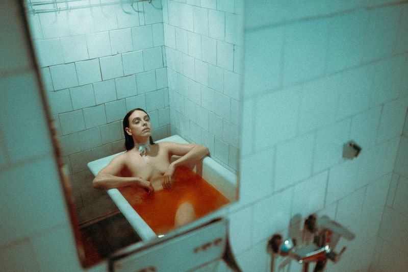 голая девушка ню ванна кафель старая комната сигарета дым грудь ванная комната лента вода мокрая капли депрессия арт купание в красной водеphoto preview