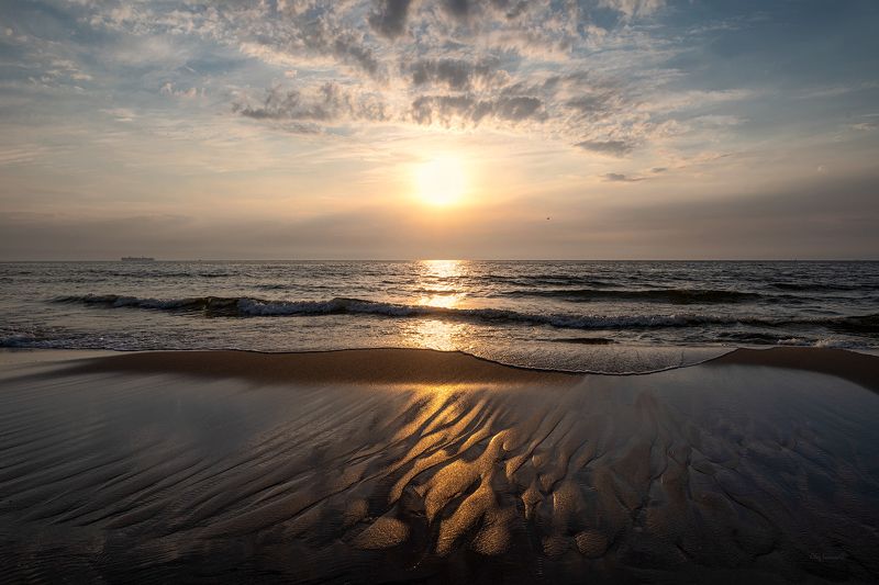 Рисует море на песке фото превью