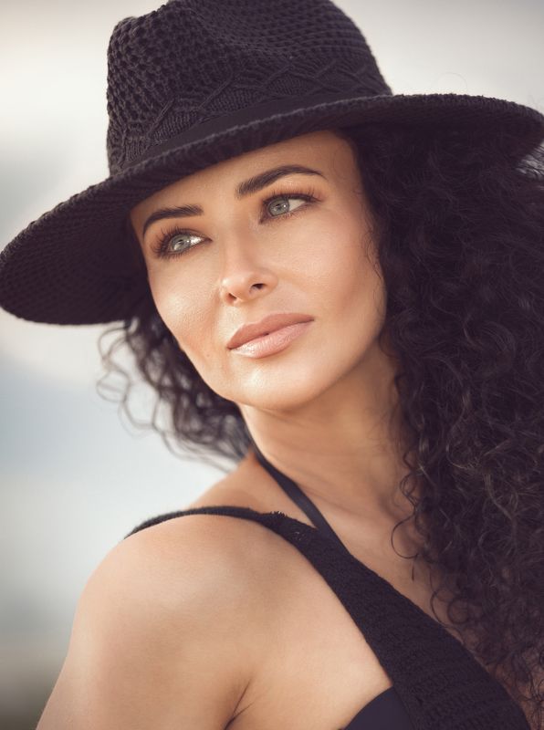 female model,  curly hair, crochet dress, black dress, lady,  elegant, beauty, eyes, moody, black hat, elegant lady, stylish face, stunning woman \