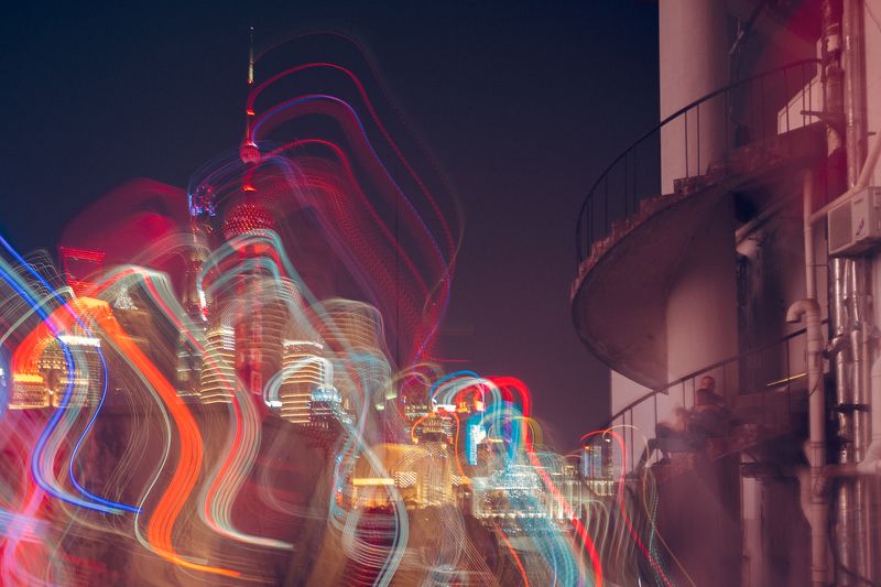 city lights, vibrant buildings, light trails, colorful palette, spiral staircase, hotel emergency exit, light show, metropolis skyline, urban night scene, couple watching lights, cityscape photography, night skyline view, urban trails of light, colorful u Urban Luminous Romancephoto preview