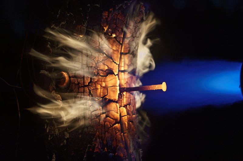 fire closeup, burning wood, fiery tree trunk, intense flames, cracked wood, glowing orange, hot wood texture, rocket-like fire, powerful blaze, resilient wood, molten iron nail, heat resistance, blue fire light, enchanting flames, magical fire beauty. Wood\'s Dance with Flamesphoto preview