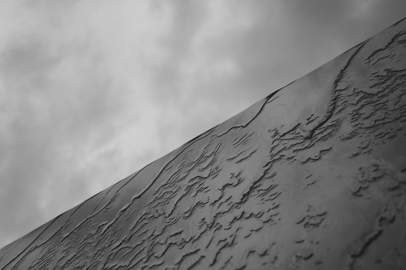 black and white photo, diagonal frame composition, grey cloudy sky contrast, waterfall on slick wall, monochrome landscape, minimalist nature scene, dramatic diagonal division, grey sky and waterfall contrast, contemporary monochrome image, aesthetic diag Waterphoto preview