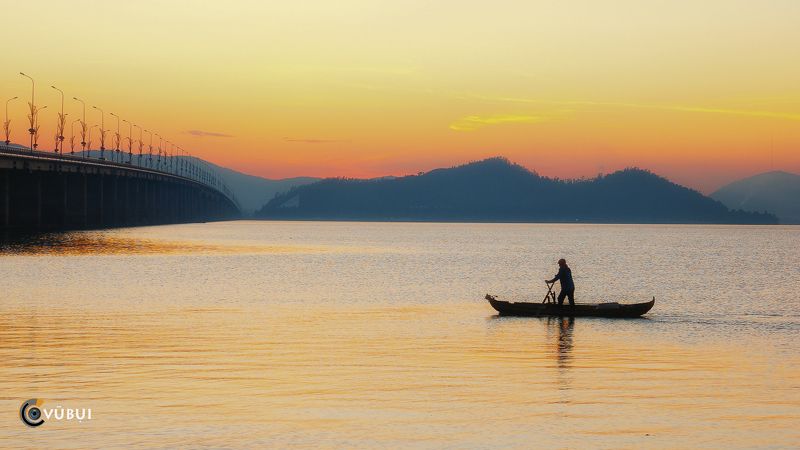 Thi Nai lagoon, Vietnam, boatman, small boat, calm water, sunrise Loneliness before dawnphoto preview