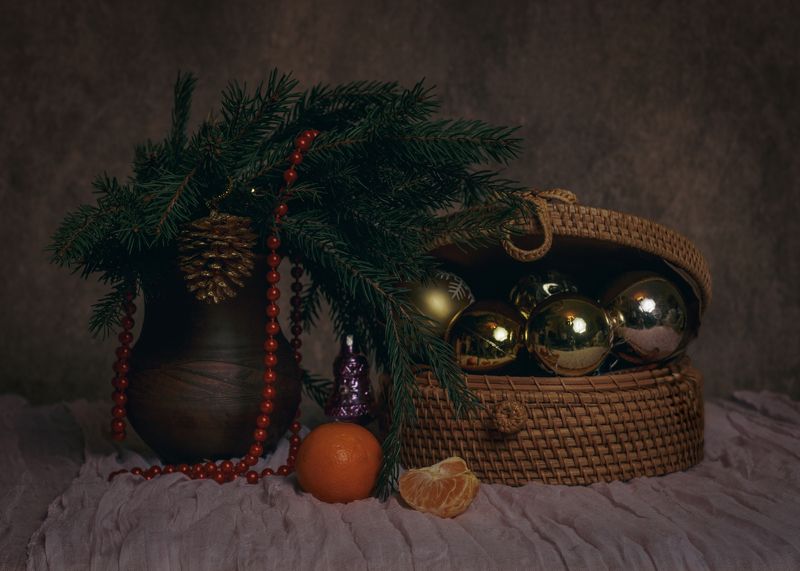 натьрморт, новогодний натюрморт, еловая ветка, шишка, плетеная шкатулка, елочная игрушка, мандарин, оранжевый, красный, красные бусы, глиняный горшок, долька мандарина, коричневый фон Долька мандаринкиphoto preview