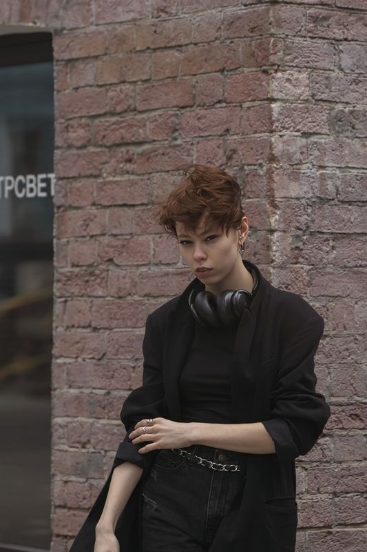 девушка, современный город, кирпичная стена, стеклянная витрина, черная одежда, шорты, наушники, лето Звуки городаphoto preview