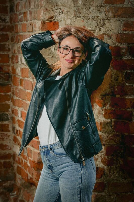 Красивая девушка в кожаной куртке на фоне кирпичной стены.photo preview