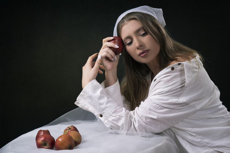 portrait, woman, apple, temptation, studio photography, fine art, contemplative, soft light, white clothing, symbolism, still life, emotion, classic beauty, renaissance style, visual storytelling, artistic pose, silence, introspection Red Fruit of Memoryphoto preview