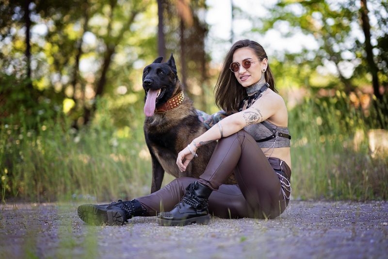 woman with dog, Belgian Malinois, tattoos, urban style, leather pants, female empowerment, alternative fashion, edgy look, loyalty, street portrait, fashion and animal, summer light, outdoor portrait, fierce bond, confident woman Alpha Bondphoto preview
