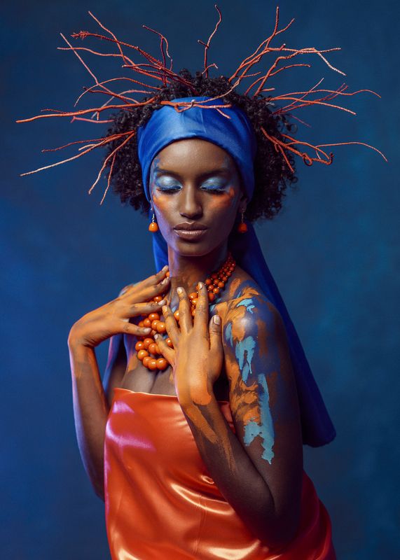 african beauty, amber accents, blue headscarf, body art, bold colors, contrasting light, creative makeup, curly hair, dark skin, delicate pose, earrings, exotic elegance, expressive hands, female portrait, fine art, necklace, side view, young woman Crown of Shebaphoto preview