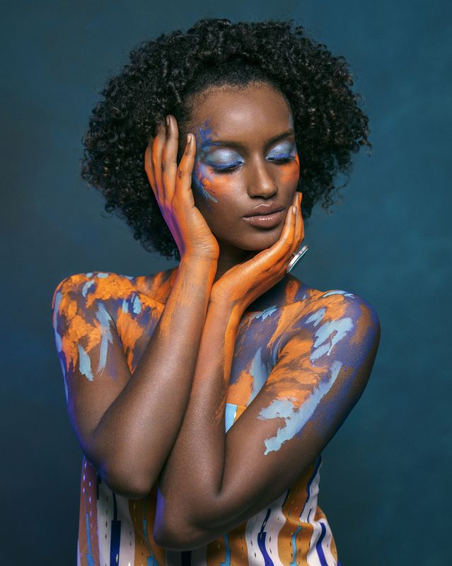 african beauty, amber accents, artistic portrait, blue eyeshadow, body art, bold colors, color harmony, creative makeup, curly hair, dark skin, ethnic style, exotic elegance, expressive hands, fine art, front view, painted body, vibrant colors Indigo Enigmaphoto preview