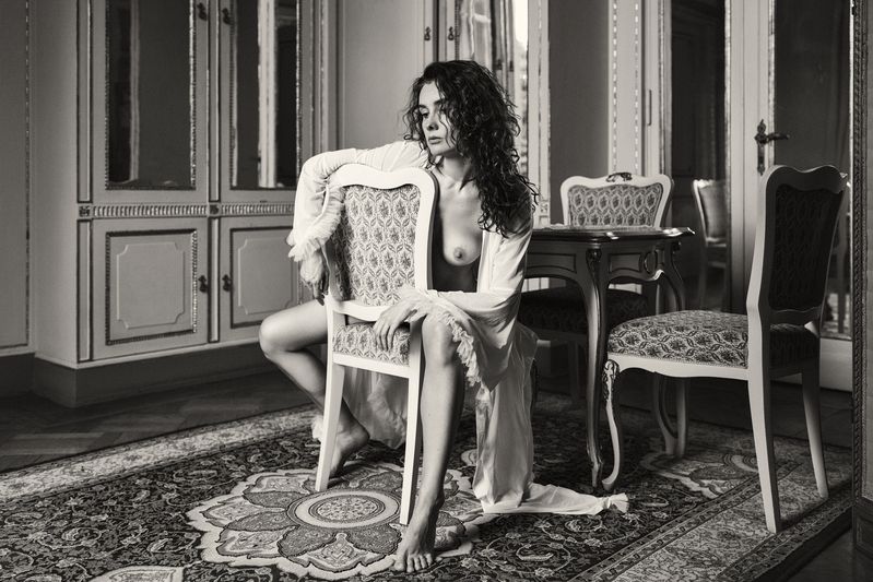 antique interior, artistic nude, chair pose, curly hair, emotional depth, fine art, gilded mirrors, intimate atmosphere, monochrome style, nostalgic tone, ornate furniture, poetic sensuality, romantic nude, sensual silence, vintage aesthetic, woman form Portrait of Longingphoto preview