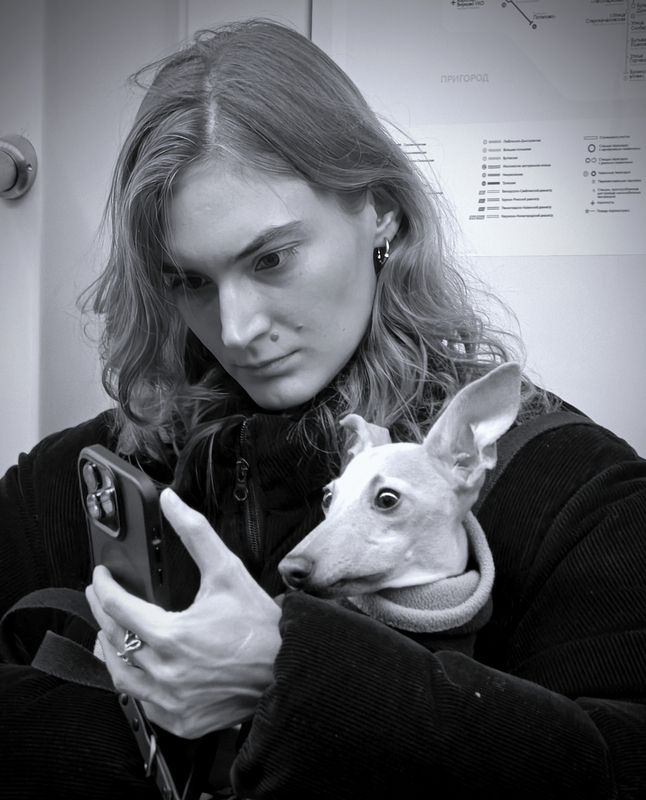 Собачка и ее хозяйка читают новости в вагоне метро.photo preview