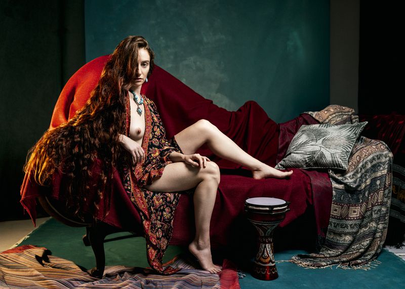 bohemian textiles, draped fabric, emerald background, exotic interior, feminine power, flowing hair, jewel tones, mythic nude, opulent setting, painterly light, poetic sensuality, reclining nude, rich textures, romantic orientalism, sculptural pose Scheherazade Before Dawnphoto preview