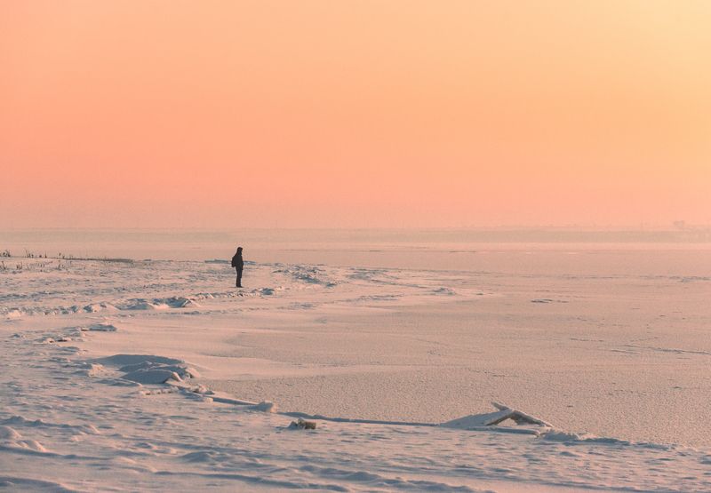 зима, снег, лед, человек, одиночество, минимализм, пейзаж, закат, пастель, тишина, спокойствие, созерцание, простор, холод, замерзшее озеро, фигура, берег, розовая дымка. Наедине с горизонтомphoto preview