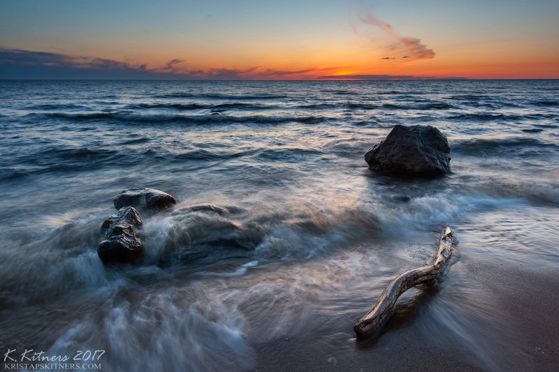 sea seascape water sky clouds stone sand stream flow tree wood reflection sunset evening latvia Companyphoto preview