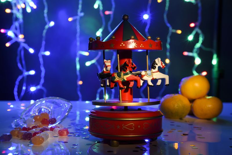 Новогодний натюрморт, карусель, деревянные лошадки, игрушечная карусель, игрушечная карусель с лошадками, Рождество, Новый год, праздник, гирлянды,мандарины, леденцы, подарки Новогодние лошадкиphoto preview