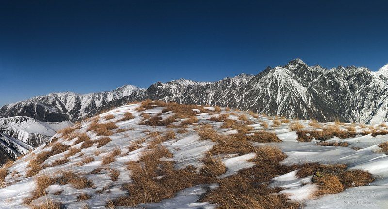 горы, Грузия, Кавказ, Казбеги, трава, зима, снег, горная местность, склон, обрыв, голубое небо Казбегиphoto preview