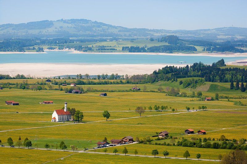 фотография с полем одуванов, дорожками, озером, церквушкой Colomanskirche и одиноким дельтапланеристомphoto preview