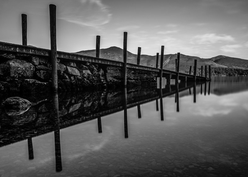 water reflection monochrome england lake mountains sky stones rocks rock stone uk blackandwhite white black contrast photography sky clouds relaxing Jetty reflectionphoto preview